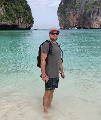 I’m standing in the turquoise waters of Thailand with stunning cliffs behind me.